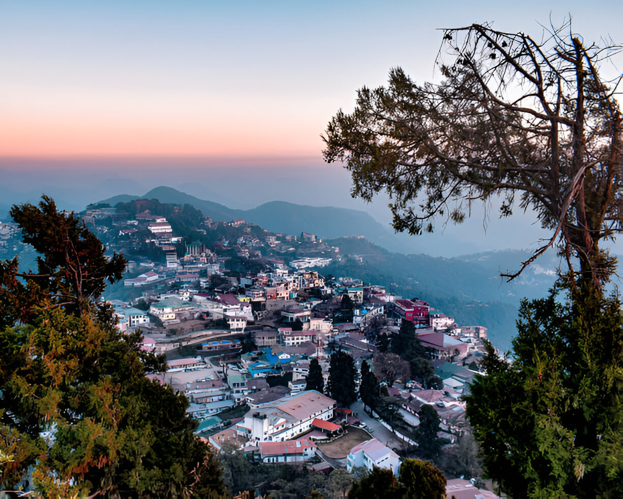 Gun Hill, Mussoorie View – "Scenic view of Gun Hill, Mussoorie, with the snow-capped Himalayas and Doon Valley in the background.