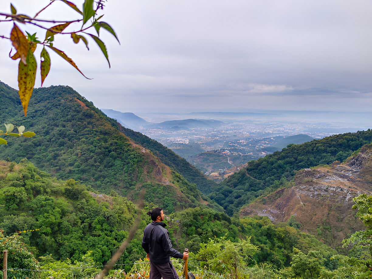An aerial shot of Mussoorie’s lush green hills with winding roads leading to the George Everest House.