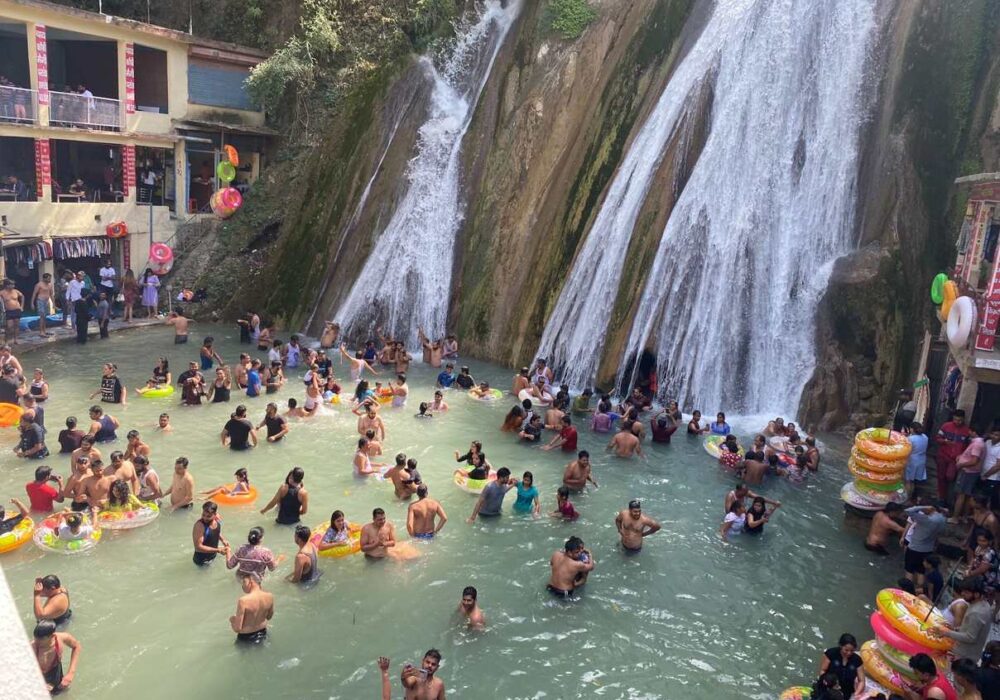 Tourists enjoying a refreshing dip in the natural pool along Kempty Fall Road, Uttarakhand.