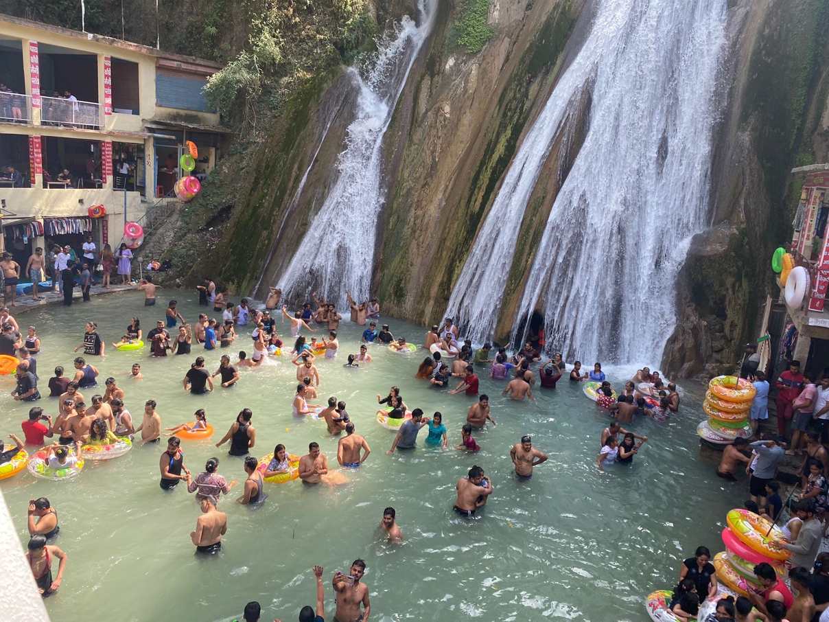 Tourists enjoying a refreshing dip in the natural pool along Kempty Fall Road, Uttarakhand.